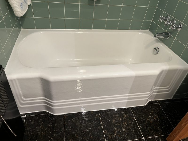 Refinished white alcove bathtub with green tile surround by Blackstone Tub Refinishers Calgary